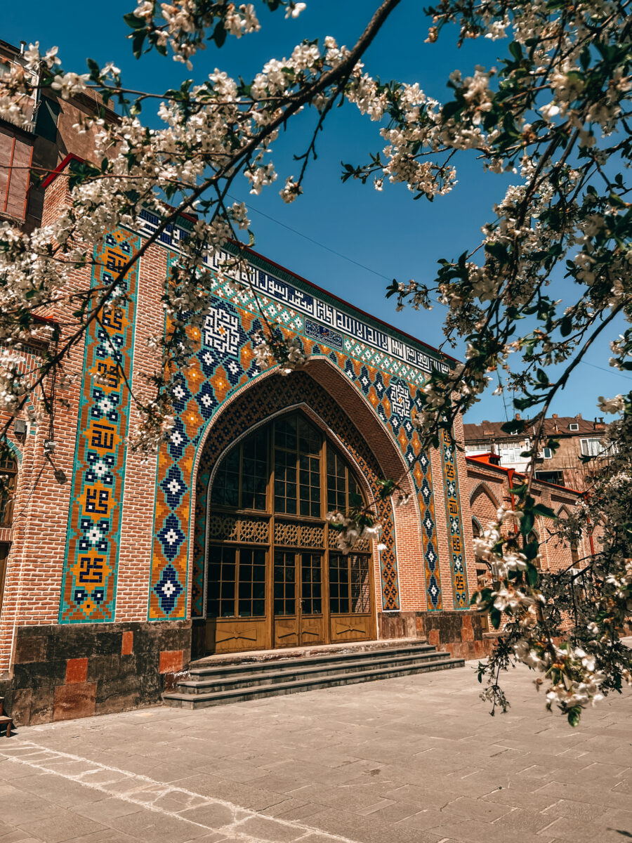 Tiled entrance of the Blue Mosque in Yerevan framed by blossoming branches, Armenia